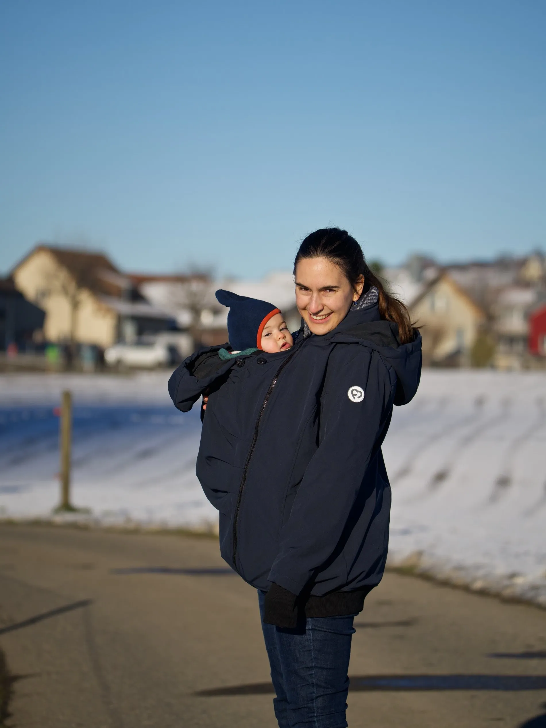 Carla unterwegs im Winter, ihr Baby in der Tragejacke